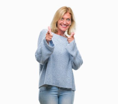 Fotoğraf makinesi ile mutlu ve komik yüz için parmakları işaret izole arka plan üzerinde kış kazak giyen orta yaş sarışın kadın. İyi enerji ve vibes.