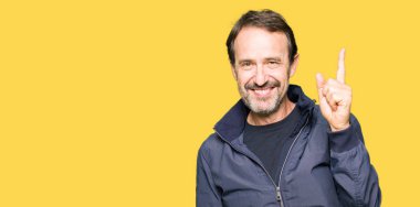 Orta yaş yakışıklı erkek ceket işaret eden bir parmağa başarılı fikirle giyiyor. Çıktıktan ve mutlu. Bir numara.