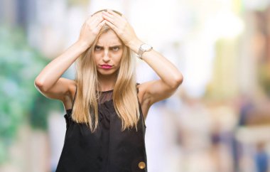 Genç güzel sarışın ve mavi gözlü kadın izole arka plan çünkü umutsuz ve stresli baş ağrısı acı yüzünden acı ve migren. Ellerini kafasına.