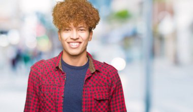 Yüzünde mutlu ve güzel bir gülümseme ile ceket afro saçlı genç yakışıklı öğrenci. Şanslı kişi.