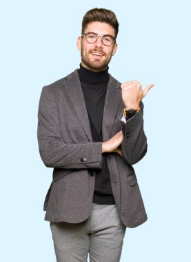 Seyir ve başparmak yanında yukarıyı mutlu yüz ile gülümseyen gözlüklü genç yakışıklı iş adamı.