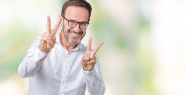 Yakışıklı orta yaş zarif üst düzey iş adamı zafer işareti yapıyor parmak gösterilen kamera seyir gülümseyen izole arka plan üzerinde gözlük takıyorum. İki numaralı.