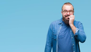 Genç beyaz hipster adam stresli ve gergin elle çivi ısırma ağzına bakarak izole arka plan üzerinde gözlük takıyorum. Anksiyete sorunu.