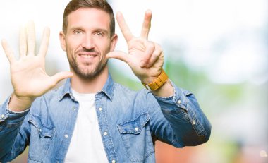 Sakal üzerinde gösterilen ve parmakları ile işaret denim ceket ve mavi gözlü yakışıklı adamla kendinden emin ve mutlu gülümseyerek süre sekiz numara.