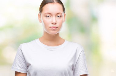 Genç güzel beyaz kadın yüzünde ciddi bir ifade ile izole arka plan yüzünden. Basit ve doğal kameraya bakıyor.