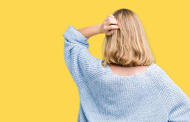 İzole arka plan geriye düşünme hakkında şüphe ile baş taraftan üzerinde mavi kazak giyen güzel genç kadın