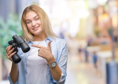 Dürbün izole arka plan üzerinde çok mutlu el ve parmak ile işaret tutan genç beyaz kadın