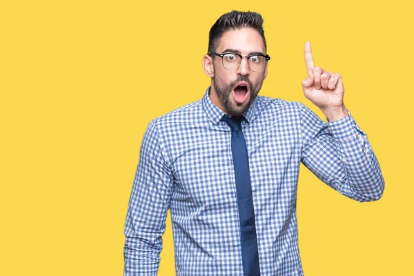 Başarılı fikirle izole arka plan işaret parmağı üzerinde gözlük takan genç iş adamı. Çıktıktan ve mutlu. Bir numara.