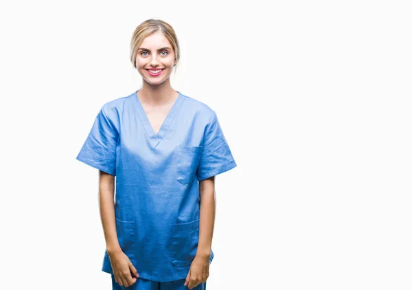 年轻美丽的金发医生外科护士妇女在孤立的背景与一个愉快和凉爽的笑容在脸上 幸运的人 — 图库照片