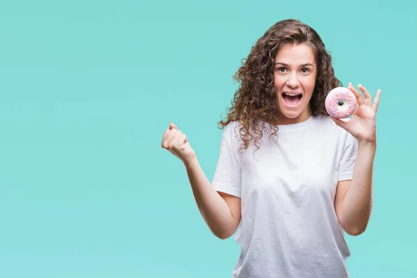 Jovem Morena Comendo Donut Sobre Fundo Isolado Gritando Orgulhoso Celebrando — Fotografia de Stock