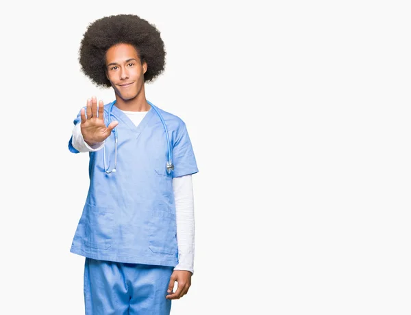 年轻的非洲裔美国医生与非洲头发做停止唱歌与手掌的手 脸上带有负面和严肃手势的警告表情 — 图库照片