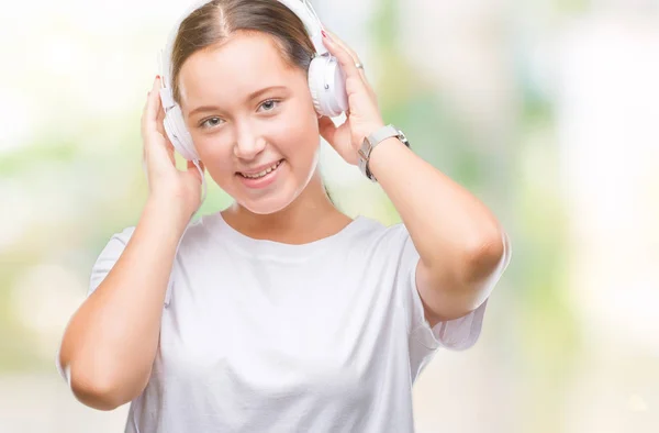 Jovem Caucasiana Ouvindo Música Usando Fones Ouvido Sobre Fundo Isolado — Fotografia de Stock