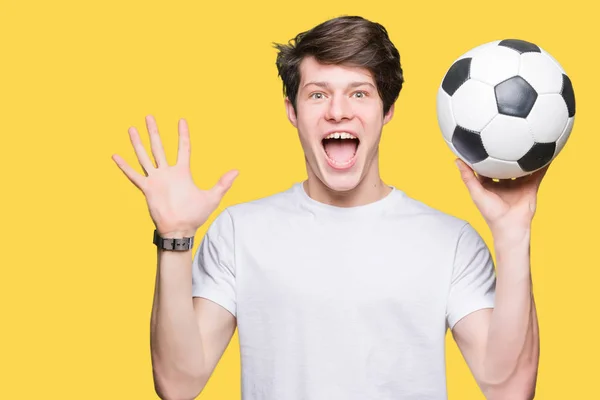 Joven Sosteniendo Pelota Fútbol Sobre Fondo Aislado Muy Feliz Emocionado —  Fotos de Stock