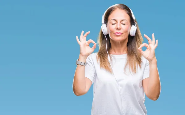 中年西班牙妇女听音乐戴耳机在孤立的背景放松和微笑闭着眼睛做冥想手势用手指 瑜伽概念 — 图库照片