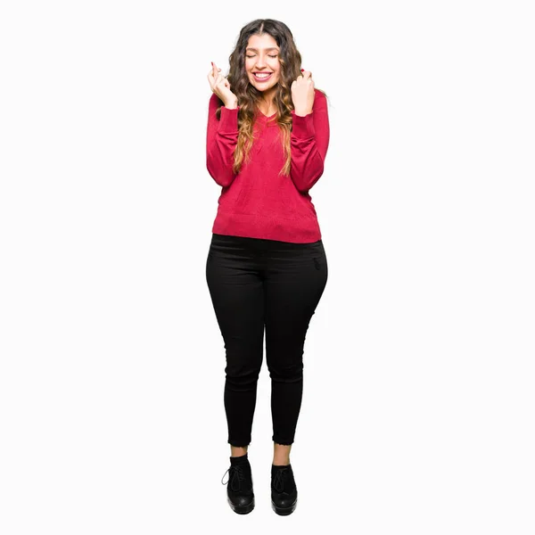 Mujer Hermosa Joven Vistiendo Suéter Rojo Sonriendo Cruzando Los Dedos —  Fotos de Stock