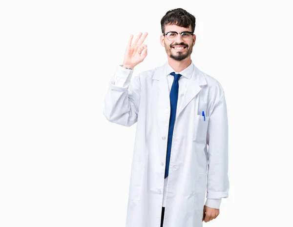 若いプロの科学者男は孤立した背景を浮かべて手と指で サインをしている肯定的な上白いコートを着ています 成功した式 — ストック写真
