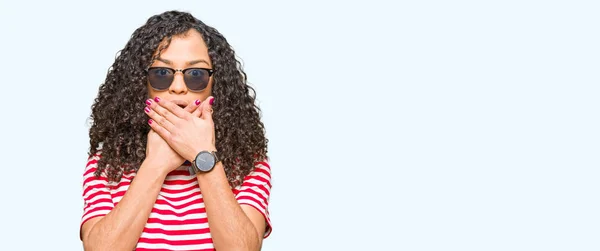 Young Beautiful Woman Curly Hair Wearing Sunglasses Shocked Covering Mouth — Stock Photo, Image