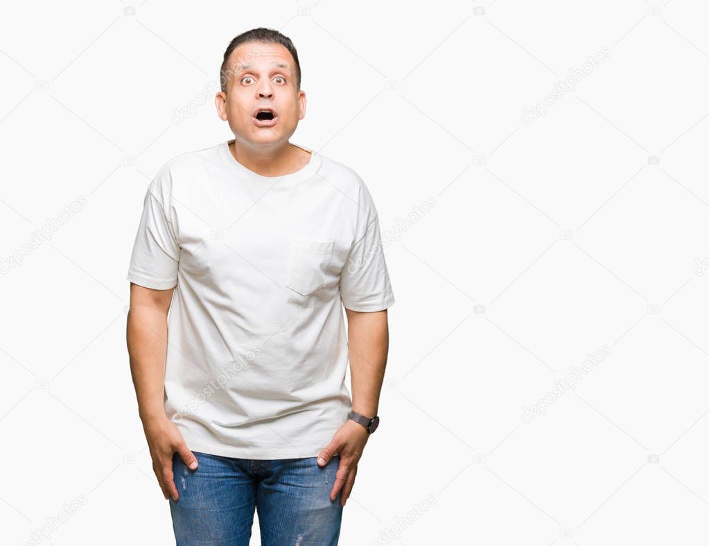 Middle age arab man wearig white t-shirt over isolated background afraid and shocked with surprise expression, fear and excited face.