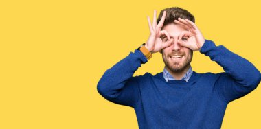 Dilini, parmaklarının arasından baktığını yapışmasını dürbün gibi ok jest yapan genç yakışıklı bussines erkek. Deli ifade.