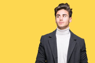 Zarif delikanlı görünümlü yan ve dik dik bakma uzağa düşünce gülümseyen izole arka plan üzerinde kış palto giyiyor.