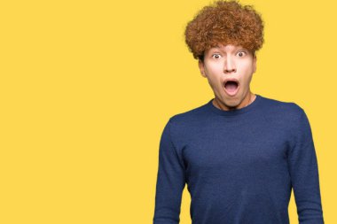 Young handsome man with afro hair In shock face, looking skeptical and sarcastic, surprised with open mouth clipart