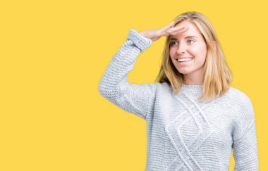 Üzerinde kış kazak giyen güzel genç kadın arka plan çok mutlu ve gülümseyen uzakta el ile üzerine kafa seyir izole. Arama kavramı.