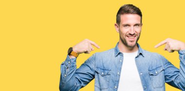 Yüzünde gülümseme ile kendinden emin görünüyorsun, kendini gururlu ve mutlu parmakları ile işaret denim ceket giyen sakal ve mavi gözlü yakışıklı adamla.