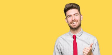 Genç yakışıklı iş adamı mutlu yaşasın el hareketini yapıyor. Başarı gösteren kameraya bakarak ifade onaylama.