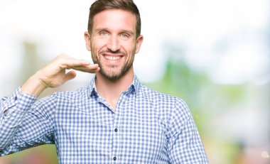 Büyük ve büyük boy işaret, ölçü birimi sembol gösteren elleriyle işaret mavi gözlü yakışıklı işadamı. Kameraya bakarak gülümsüyordu. Ölçüm kavramı.