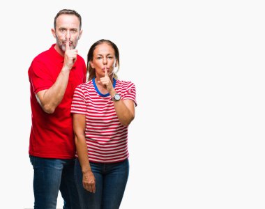 Orta yaş İspanyol çift aşk dudaklarında parmak ile sessiz olmanı izole arka plan üzerinde. Sessizlik ve gizli kavramı.