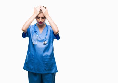 Genç güzel sarışın doktor cerrah hemşire kadın izole arka plan çünkü umutsuz ve stresli baş ağrısı acı acı ve migren. Ellerini kafasına.