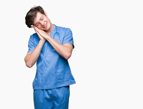 Joven Médico Vistiendo Uniforme Médico Sobre Fondo Aislado Durmiendo Cansado — Foto de Stock