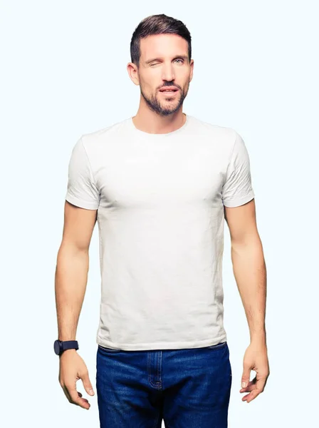Hombre Guapo Con Camiseta Blanca Casual Guiñando Ojo Mirando Cámara — Foto de Stock