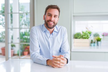 Kameraya olumlu gülümseyen yakışıklı iş adamı