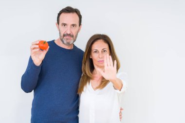 Dur işareti ciddi ve kendine güvenen ifade, savunma hareketi ile işi el ile izole arka plan üzerinde taze domates yeme orta yaş kaç açın