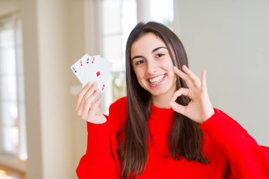 Güzel genç kadın parmakları, mükemmel sembolü olan ok işareti yapıyor poker oynamaya kumar