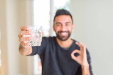 İspanyol yakışıklı parmak, mükemmel sembolü ile ok işareti yapıyor su taze bir kadeh içmek