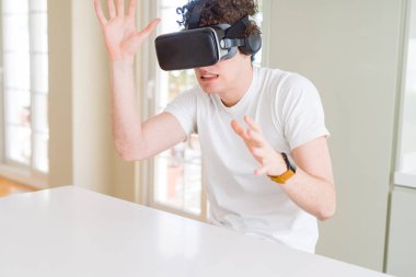 Genç adam eğleniyor evde sanal gerçeklik gözlüklü