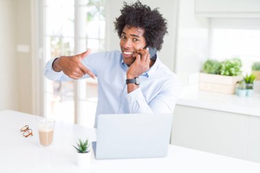 Kendisi için sürpriz yüz işaret parmağı ile telefonda konuşurken Afrikalı-Amerikalı iş adamı