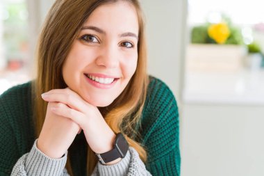 Kameraya emin gülümseyen güzel genç kadın