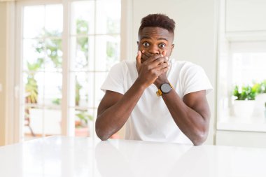 Afro-Amerikan yakışıklı beyaz tablo evde kapsayan ağız elle hata için şok. Gizli kavramı.