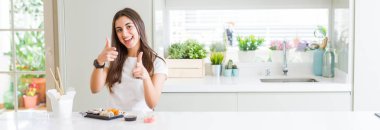 Güzel genç kadın için fotoğraf makinesi ile mutlu ve komik yüz parmakları işaret teslimatından Asya suşi yemek geniş açı resim. İyi enerji ve vibes.