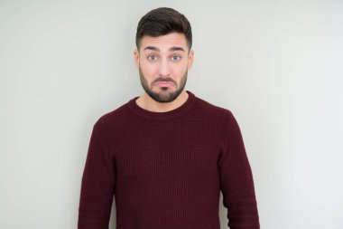 Yakışıklı delikanlı izole arka plan üzerinde bir kazak giyen depresif ve kızgın ve korkmuş ağlıyor sıkıntı için endişeleniyorum. Üzgün ifade.