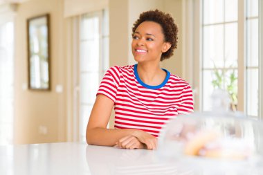 Genç güzel Afrikalı-Amerikalı kadın evde uzak tarafına yüzünde, doğal ifade gülümseme ile arıyorum. Kendine güvenen gülüyor.