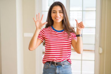 Gösterilen ve parmakları ile işaret rahat t-shirt giyen genç güzel kadın kendinden emin ve mutlu gülümseyerek süre 6 numara.