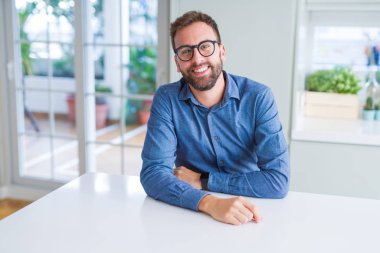 Gözlük takan ve gülümseyen yakışıklı adam kameraya rahat