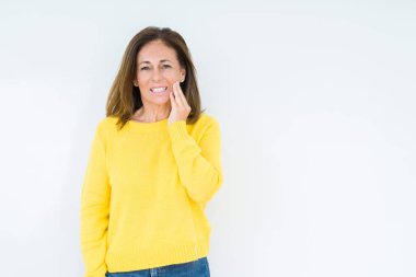 Diş ağrısı veya dişlerde dişlerle ilgili hastalık nedeniyle ağız acı ifadesi ile el ile dokunmak izole arka plan üzerinde sarı kazak giyen güzel orta yaş kadın. Diş hekimi kavramı.