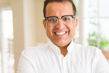 Evde kameraya gülümseyen gözlük takan orta yaş erkek