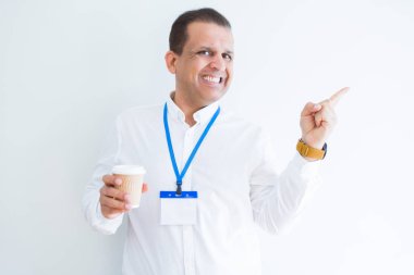 Kimlik kartı takıyor ve coffeeover beyaz arka plan el ve parmak ile tarafına işaret çok mutlu içme orta yaş iş adamı