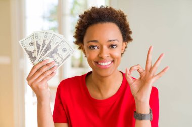 Banka notları yirmi parmak, mükemmel sembolü ile ok işareti yapıyor dolar tutan genç Afro-Amerikan kadın